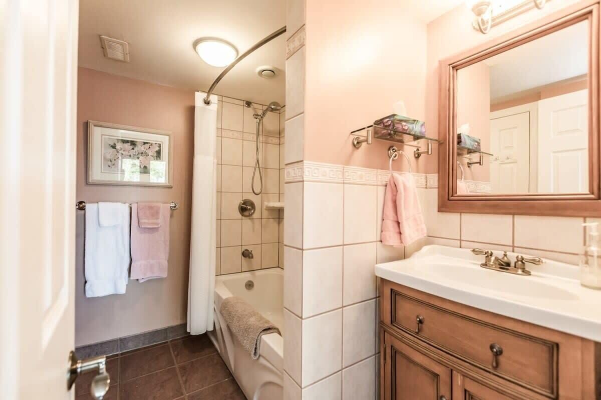 Une salle de bain avec une douche, un lavabo avec un miroir et un porte-serviettes.