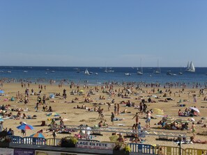 A crowded beach with people sunbathing and swimming, boats in the water, and a clear sky. - Well-located apartment, terrace with sea view. 50 m from the beach. For 2-4 pers (Les Sables-D'olonne)