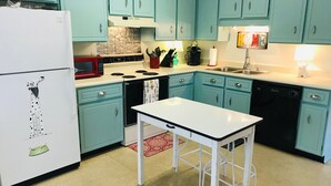 A kitchen with teal cabinets, a white refrigerator, a stove, and a sink. - Piper's Flat, Cozy, Comfy & Sparkling Clean (Aiken)