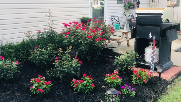 A white house with the number 135, a patio with a grill, and a garden with red flowers. - Piper's Flat, Cozy, Comfy & Sparkling Clean (Aiken)
