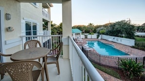 Ein Wohnbalkon mit Pool, Gartenmöbeln und Blick auf eine Wohngegend.