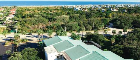 A residential area with multiple buildings, a parking lot, and a view of the ocean.