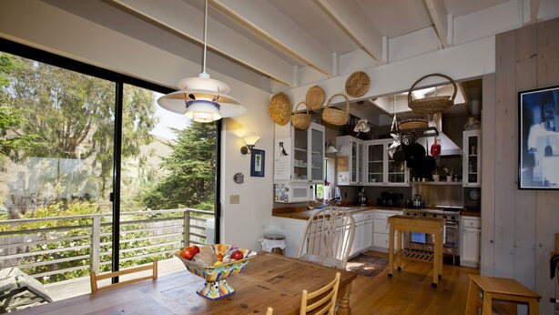 Una cocina moderna con armarios de madera, una mesa de comedor y vistas al exterior.