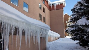 A building with icicles hanging from the roof and snow on the ground. -  LUXURY STUDIO+BUNK ROOM, VIEWS, MINS TO LIFTS /SHOPS, ONSITE HOT TUB, GARAGE (Copper Mountain)