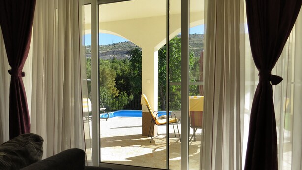 A room with a sliding glass door leading to an outdoor area with a pool and chairs. - A Mountain Escape From Everyday Life At Apartment Vilar right next to Split! (Srinjine, Split)