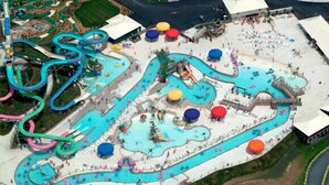 Parque acuático con múltiples piscinas, toboganes y un tobogán serpenteante.