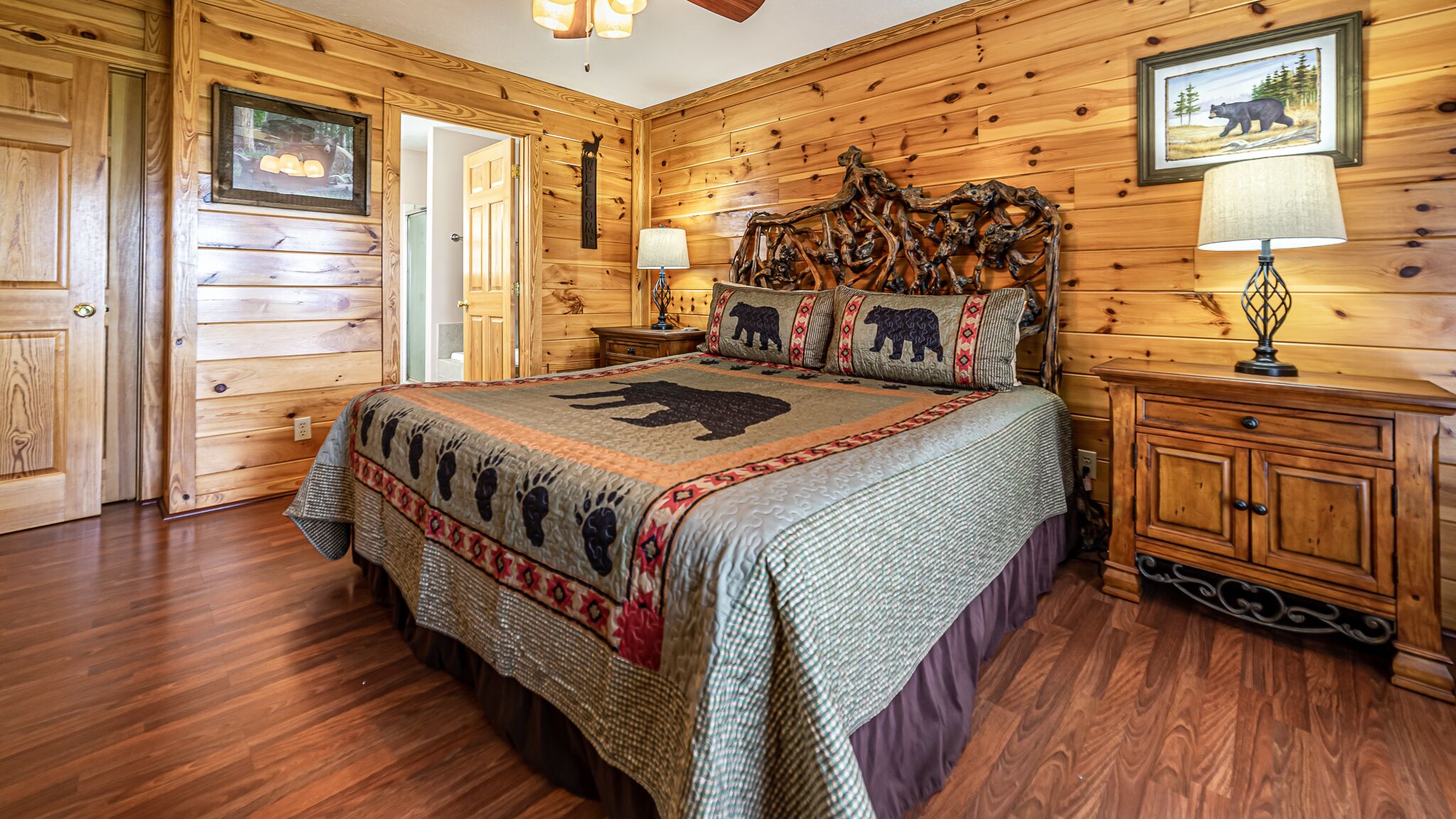 A wooden cabin bedroom with a bed, nightstands, and a dresser.