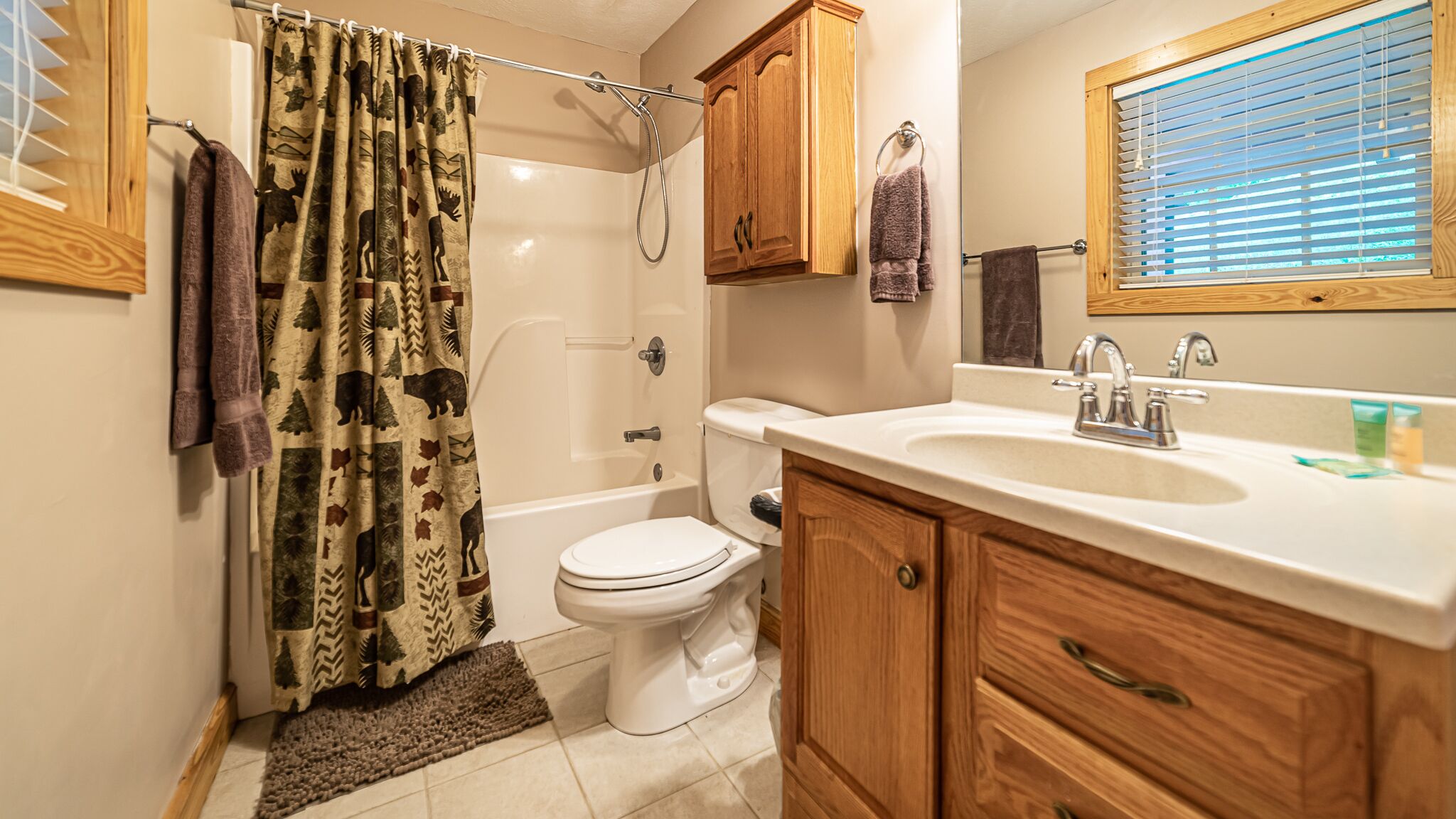 A bathroom with a shower, toilet, and sink.