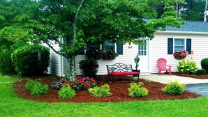 A house with a front yard, a bench, and a red chair. - We welcome Short & Long Term Guest .  (Aiken)