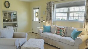 A living room with a beige sofa, two armchairs, a small table, and a lamp. There is a window with curtains and a door with a wreath. - We welcome Short & Long Term Guest .  (Aiken)