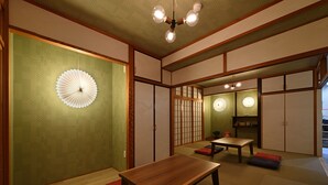 A traditional Japanese room with tatami flooring, a low wooden table, and shoji screens. - Santiago Guesthouse Naha - Hostel (Naha)