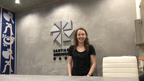 A reception area with a sign reading "SANTIAGO GUESTHOUSE" and a decorative wall with geometric patterns. - Santiago Guesthouse Naha - Hostel (Naha)