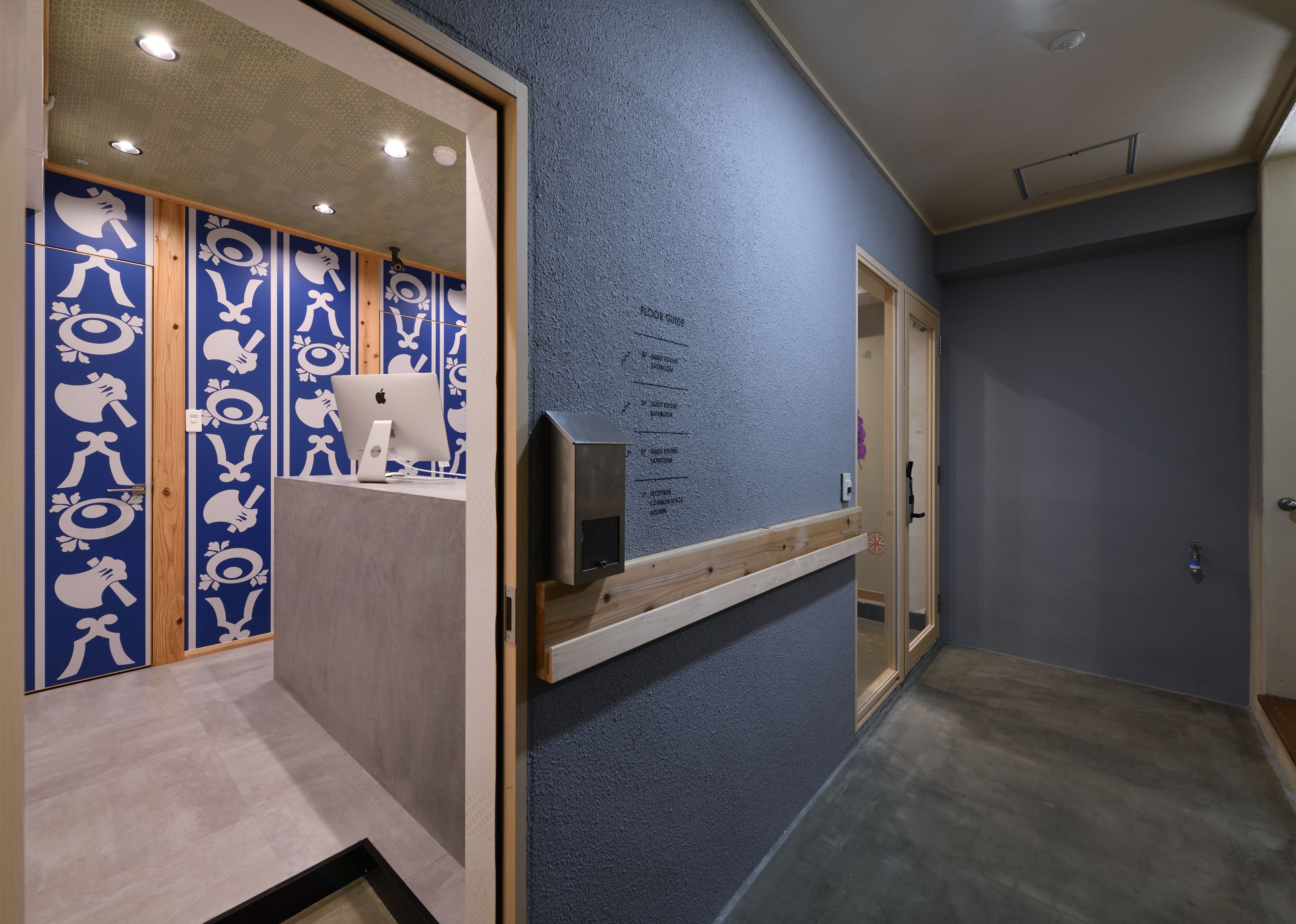 Un pasillo con pared azul texturizada, paneles de madera y una puerta con panel de vidrio.