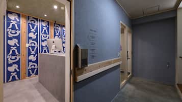 Un pasillo con pared azul texturizada, paneles de madera y una puerta con panel de vidrio.