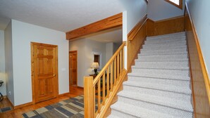Eine Treppe mit Holzwerteln und Teppichstufen, die zu einer oberen Etage führt.