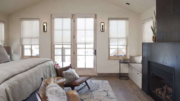 A bedroom with a large bed, a fireplace, and a view of the outside through the windows. -  Come Home To Tomorrow's Comforts in Historic CB! Book for summer soon!! (Crested Butte)