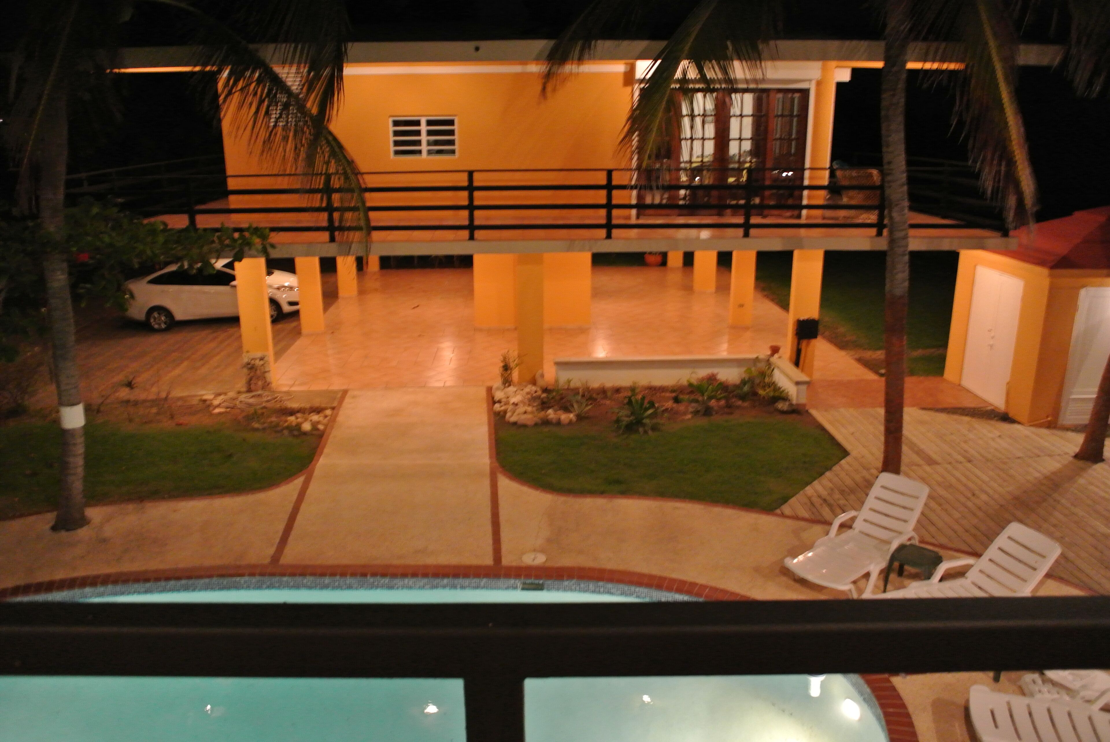 Ein Hotel mit Pool, Liegestühlen und einer überdachten Terrasse.