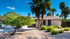 A residential area with a single-story house, palm trees, and a gravel driveway. - SUMMER Specials- Total Comfort close to Paradise Valley and Golf (Phoenix)
