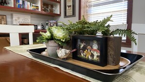 Un plateau avec des plantes en pot et une photo encadrée de champignons.
