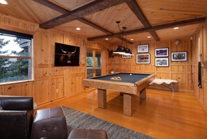 A wooden room with a pool table, a mounted moose head, and framed pictures on the wall. - Pinnacle Ridge 34 - Ski in Ski out, Private Hot Tub, Billiards, Fireplace (Whistler)