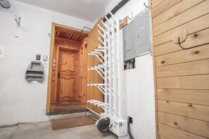 A hallway with a wooden door, a white metal rack, and a gray electrical box.
