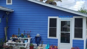 Un edificio azul con una puerta blanca identificada con la etiqueta 'Bayhouse #1 Entrada'.