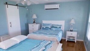 Un dormitorio con cama, mesitas de noche, armario y equipo de aire acondicionado.
