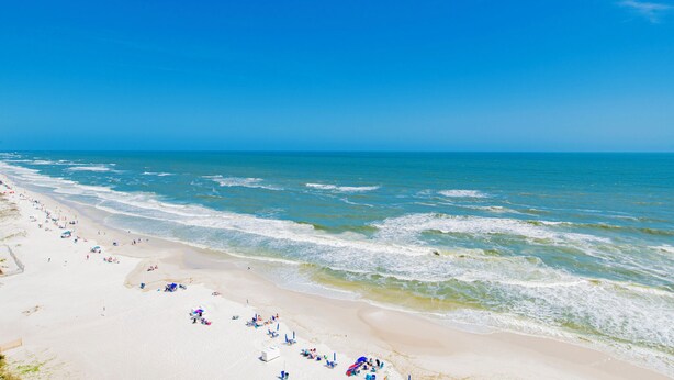 A beach with wide sandy shores and gentle waves.