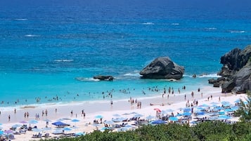 Una playa cerca, sillas reclinables de playa, toallas de playa