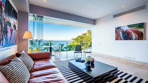 Ein modernes Wohnzimmer mit einer Ledersofa, einem Couchtisch und Blick auf das Meer.