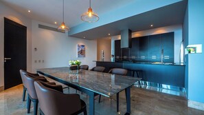 A modern kitchen with dark cabinetry, a central island, and pendant lighting.
