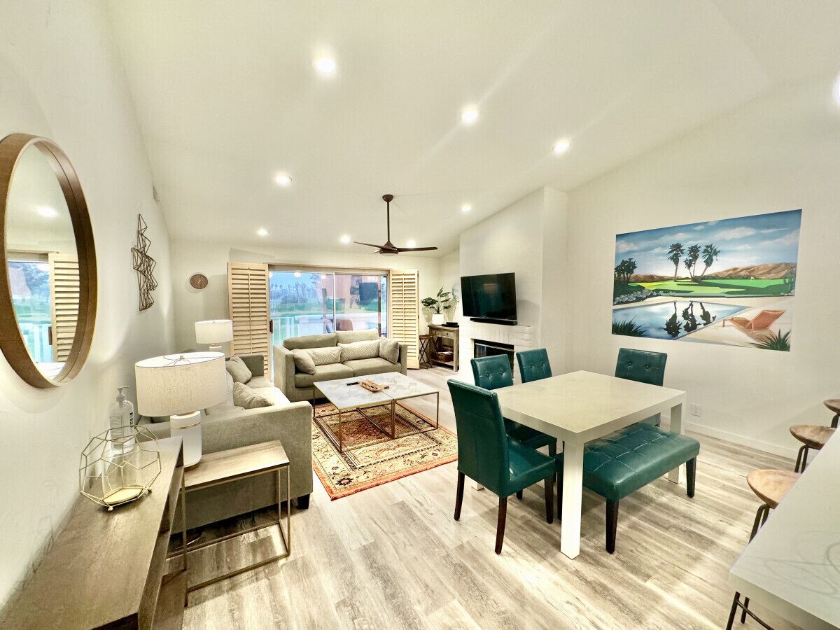 A modern living room with a sofa, coffee table, and dining area.