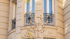 Ein Gebäude mit einer geschwungenen Fassade, zahlreichen Fenstern und Balkonen mit schwarzen Geländern.