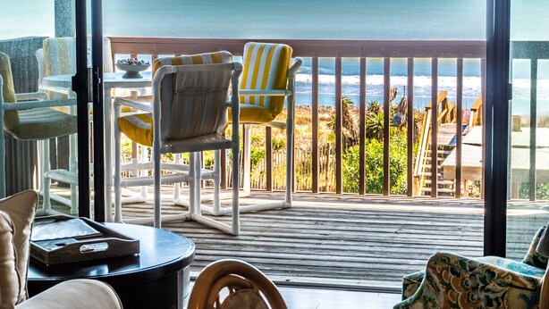 A balcony with a view of the ocean, furnished with chairs and a table. - Sea Colony 21B | Oceanfront, Private Beach Walkway (Carolina Beach)