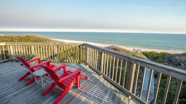 A wooden deck with red Adirondack chairs overlooking a beach. - Beachfront, Plantation, Pet Friendly (Eastpoint)