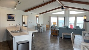 A spacious living area with a kitchen, dining table, and seating. - Beachfront, Plantation, Pet Friendly (Eastpoint)