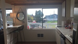 Una cocina con tragaluces, un comedor con sillas y vistas al exterior.