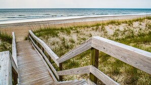 Una passerella di legno che conduce a una spiaggia con una vista libera sull'oceano.