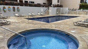 A swimming pool with mosaic tiles, surrounded by lounge chairs and a stone deck. - Read our Reviews! Newly Updated Condo! Perfect Getaway Steps to Beach & Dining! (Kihei)