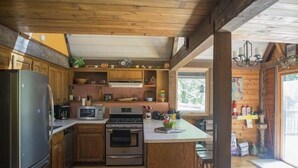 A kitchen with wooden cabinets, a refrigerator, a microwave, an oven, and a sink. - Lake MacBride Cabin & State Park! Near Amana Colonies, Iowa City & Cedar Rapids (Solon)