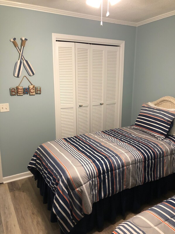 A bedroom with a bed, a closet, and a wall decoration.