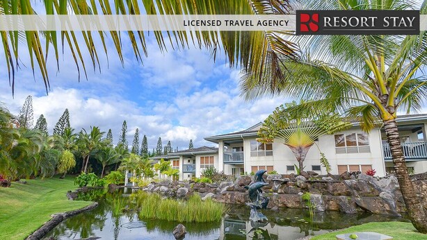 A landscaped garden with a pond, palm trees, and a building with balconies. - North Shore Beauty!  2B with Kitchen in Resort near Hanalei (Princeville)