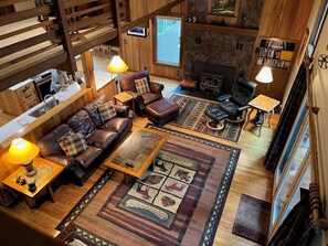 Una sala de estar acogedora con chimenea, sofás de cuero y un comedor con mesa y sillas de madera.