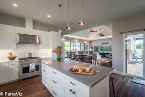Enjoy family meals and entertaining in this spacious kitchen with a large island, stove and oven, and dining area with comfortable seating.
