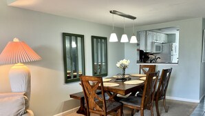 A dining area with a wooden table, chairs, and a lamp. There are three pendant lights above the table. - Peaceful Villa with Ocean and Hunting Island View (Harbor Island)