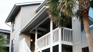 A two-story building with a wooden staircase leading to a balcony. - Peaceful Villa with Ocean and Hunting Island View (Harbor Island)