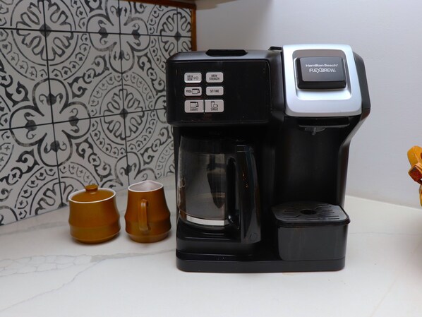 Una cafetera con un panel de control y una jarra.