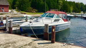 A boat docked at a marina with a red building in the background. - Walking distance to all you will need! Sleeps 8-10 (Ellison Bay)