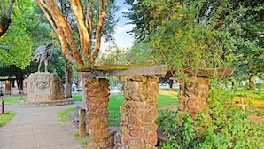 A park with a stone monument, a wooden pergola, and a stone pathway. - Close to Sonoma Plaza, Hot Tub and Bikes Included (Sonoma)
