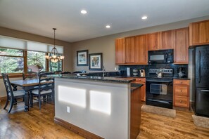 Enjoy cooking in this well-equipped kitchen with a central island, microwave, oven, and refrigerator.